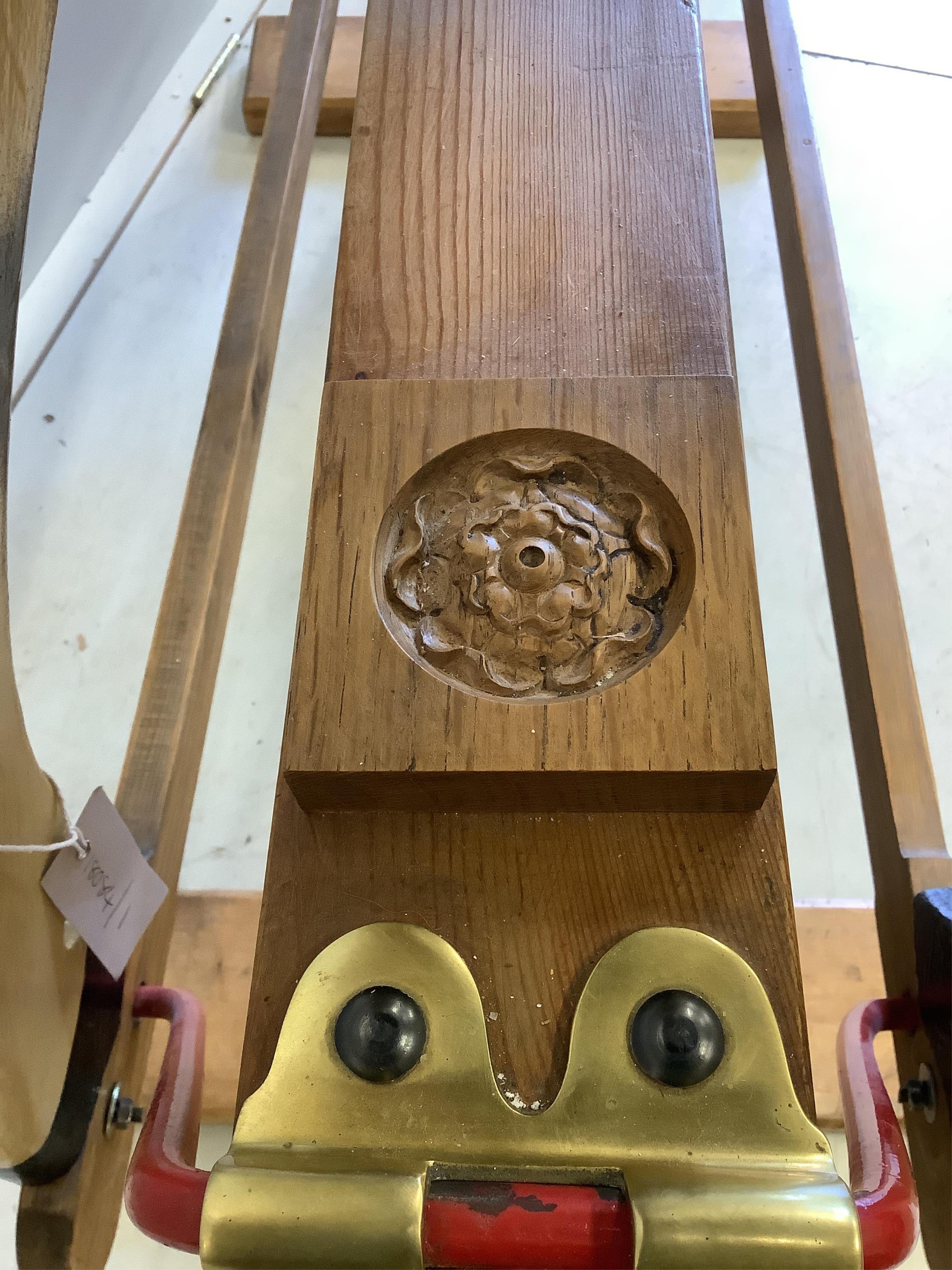 A large carved wooden rocking horse on a pine stand, the body painted in dapple grey, with glass eyes and upholstered leather saddle, height to the top of the head 130cm, length of base 152cm. Condition - fair to good.